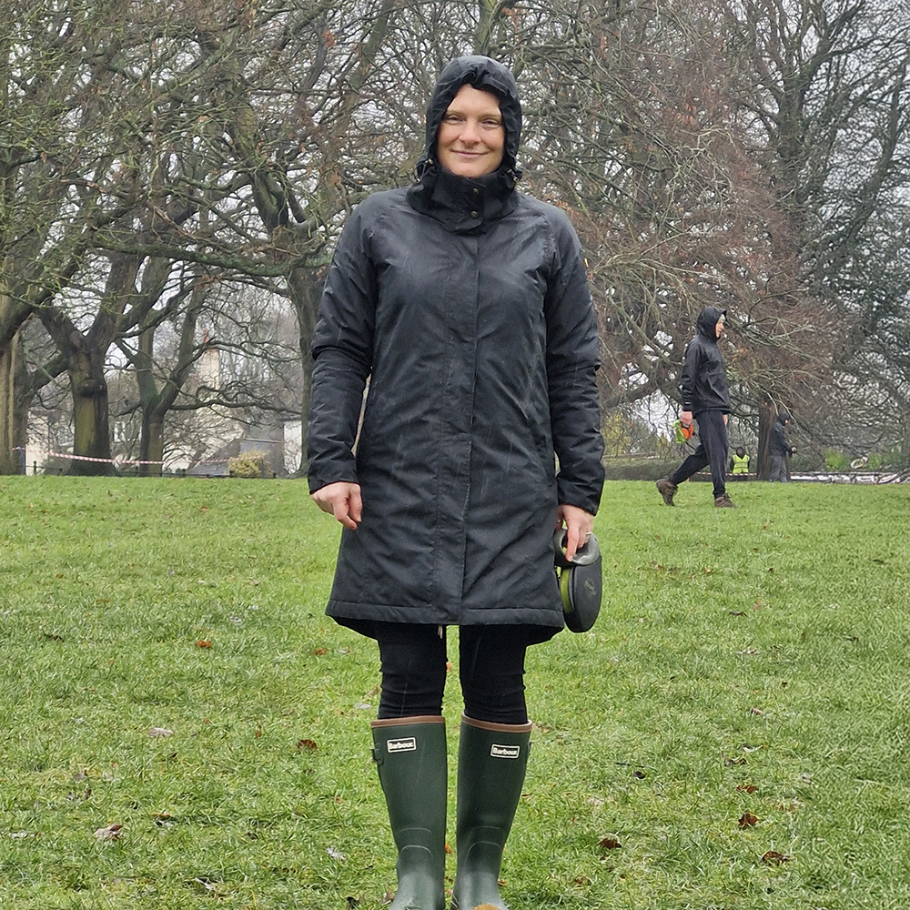Woman reviewing Barbour Tempest wellies in field with rain and mud