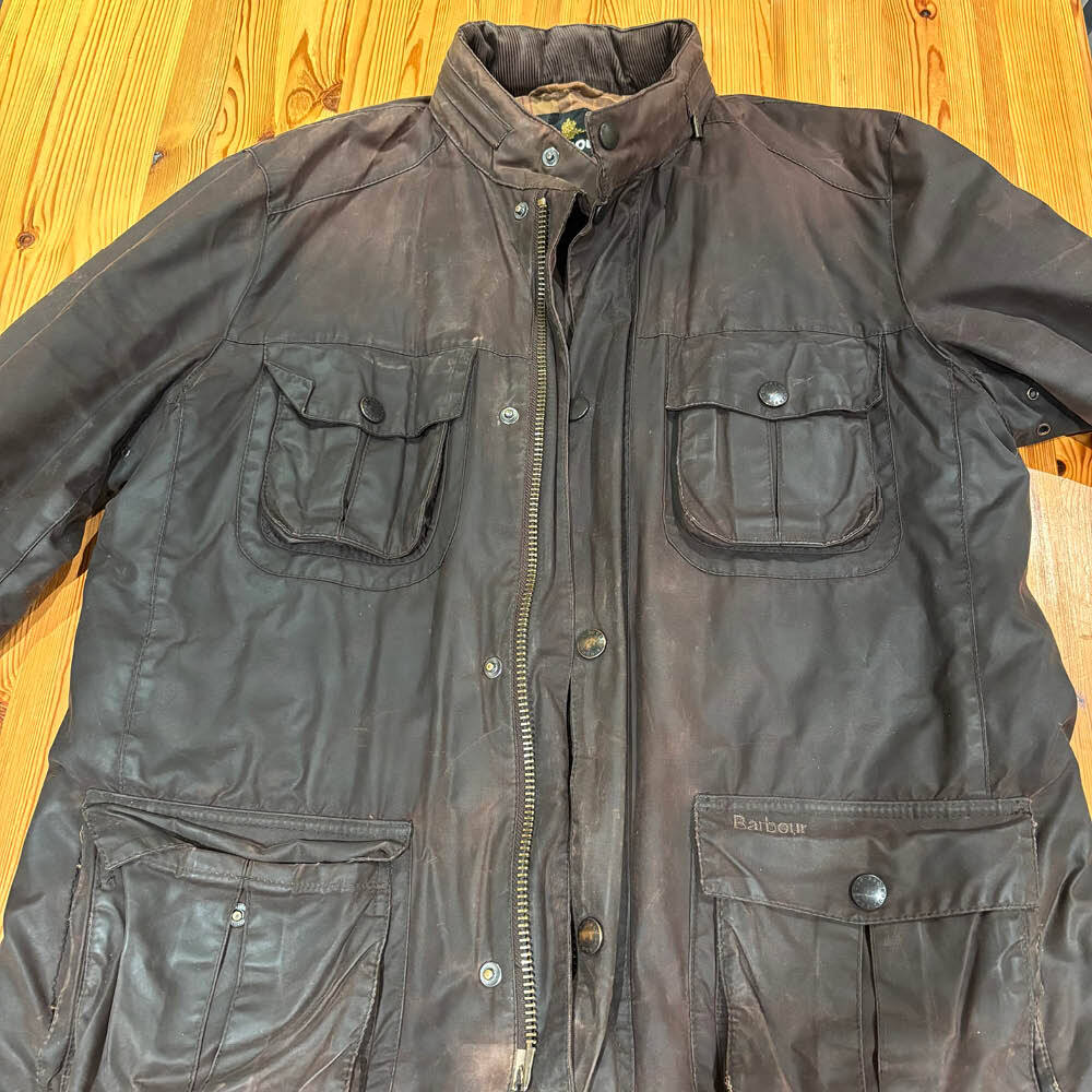Brown Barbour wax jacket showing worn and faded wax coating before rewaxing.