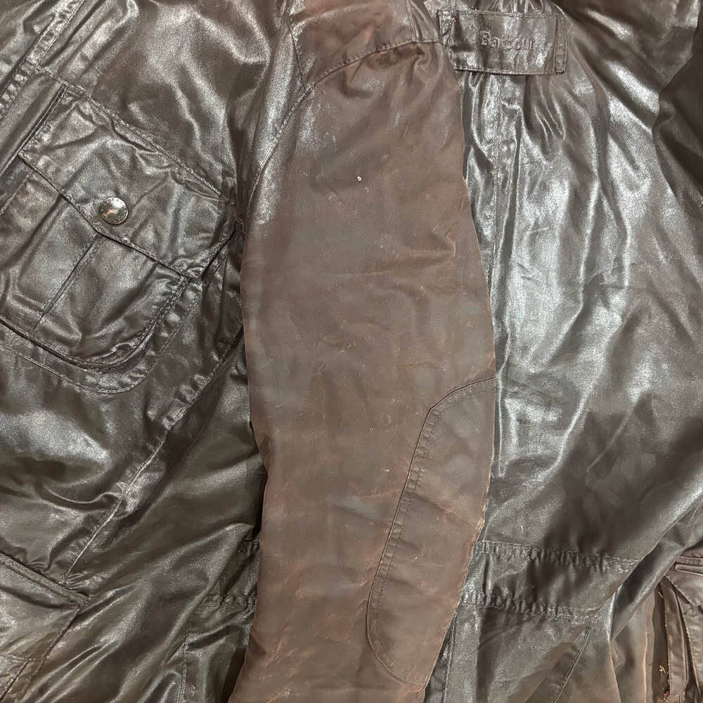 Rewaxing a Barbour Wax jacket showing a non waxed arm against a treated area