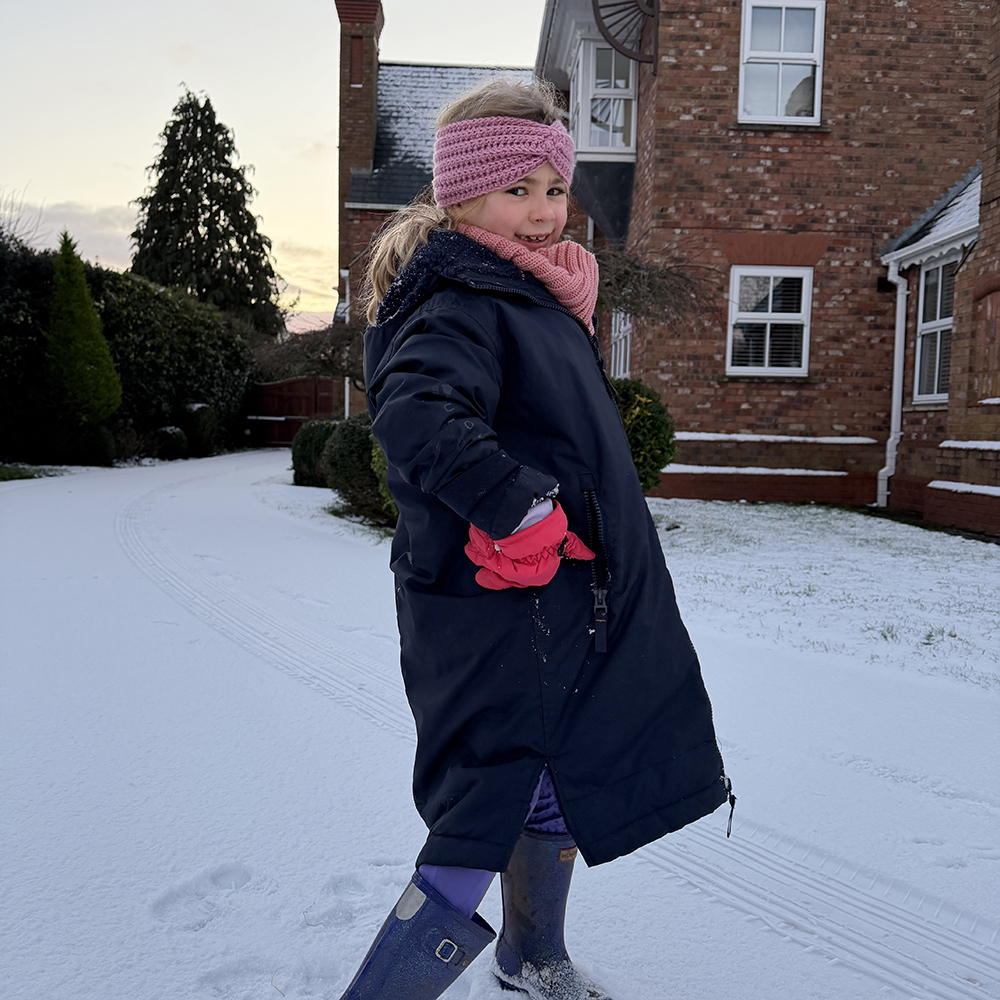 Girl wearing the Kids Aubrion All Weather Robe in the snow 