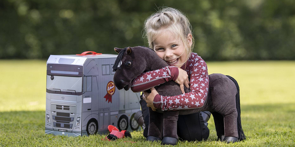 Young girl hugging her LeMieux Toy Pony Freya