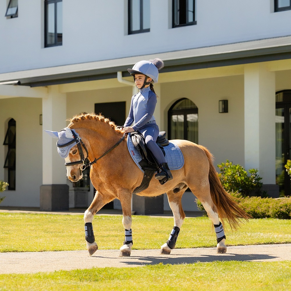 Child riding their pony both earing the new SS26 Powder Blue Mini Collection Child riding their pony both earing the new SS26 Powder Blue Mini Collection