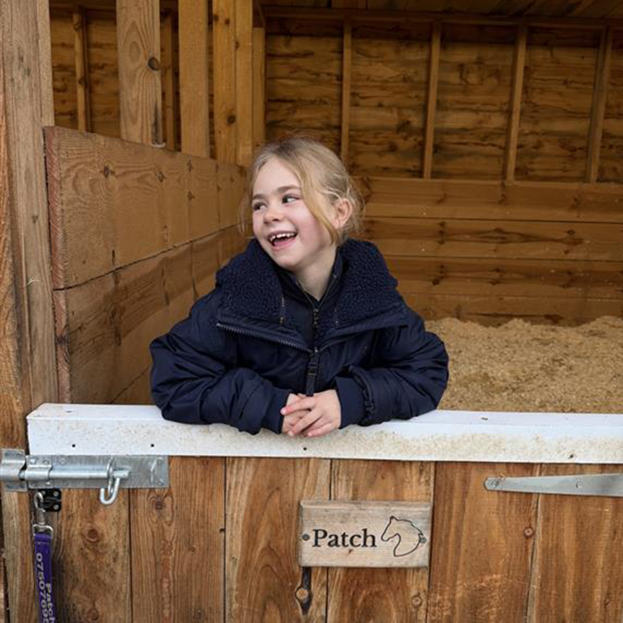 Young rider looking over stable door