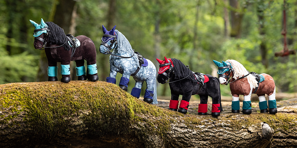 Four LeMieux Toy Ponies wearing toy pony tack with matching saddle pads and fly hoods