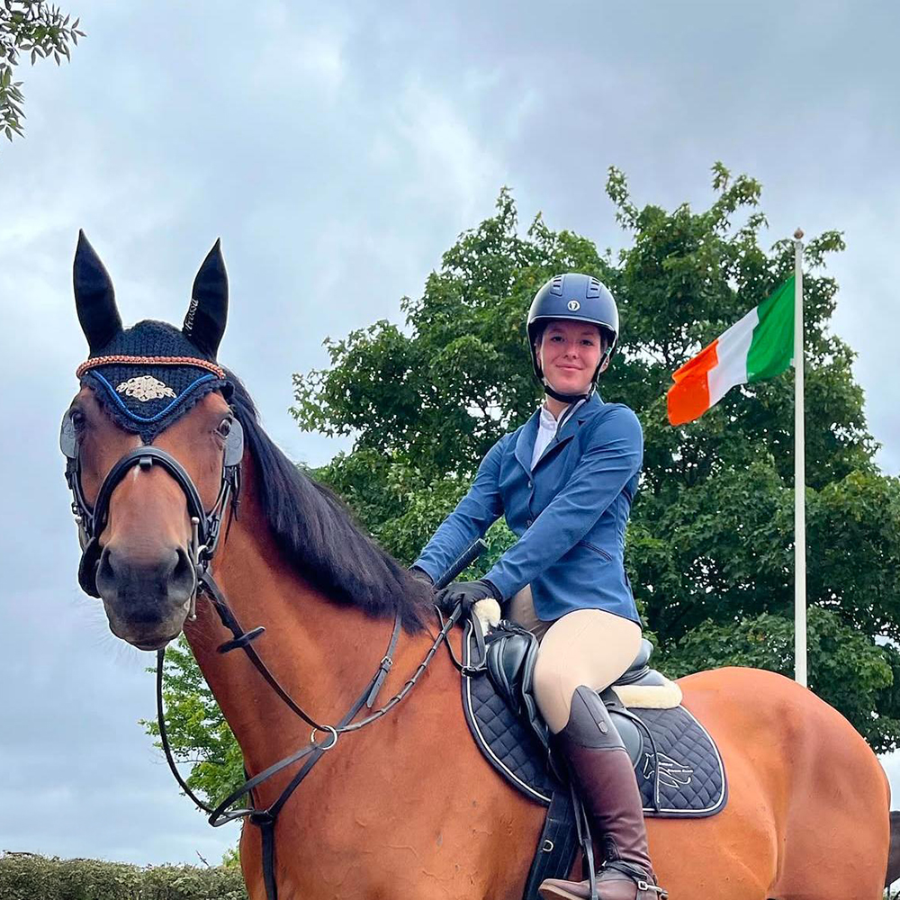 Woman riding horse at a competition wearing the Mountain Horse Ladies Sovereign High Rider in Brown