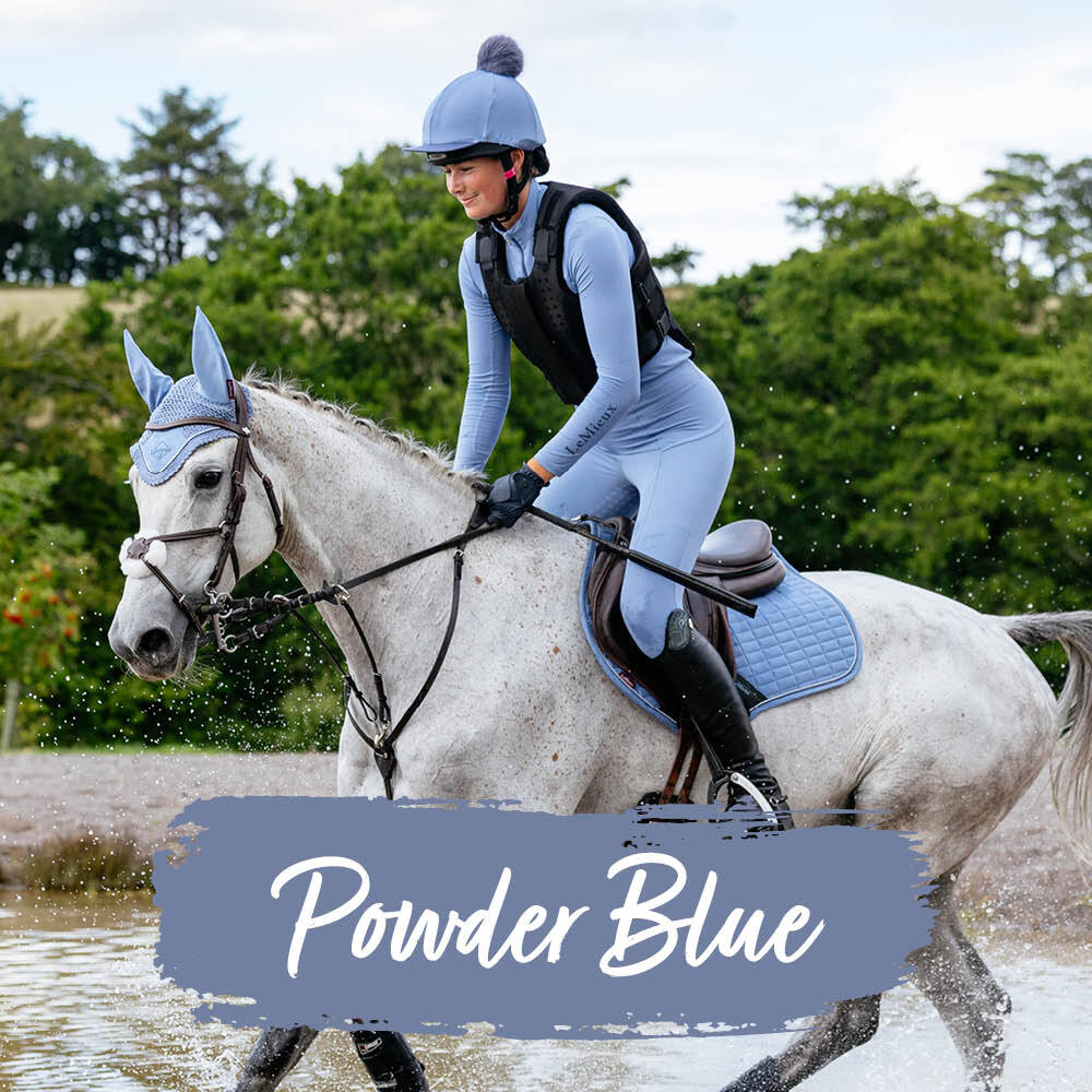 Horse and rider wearing matching New Lemieux Powder Blue saddle pad, fly hood and rider clothing Horse and rider wearing matching New Lemieux Powder Blue saddle pad, fly hood and rider clothing