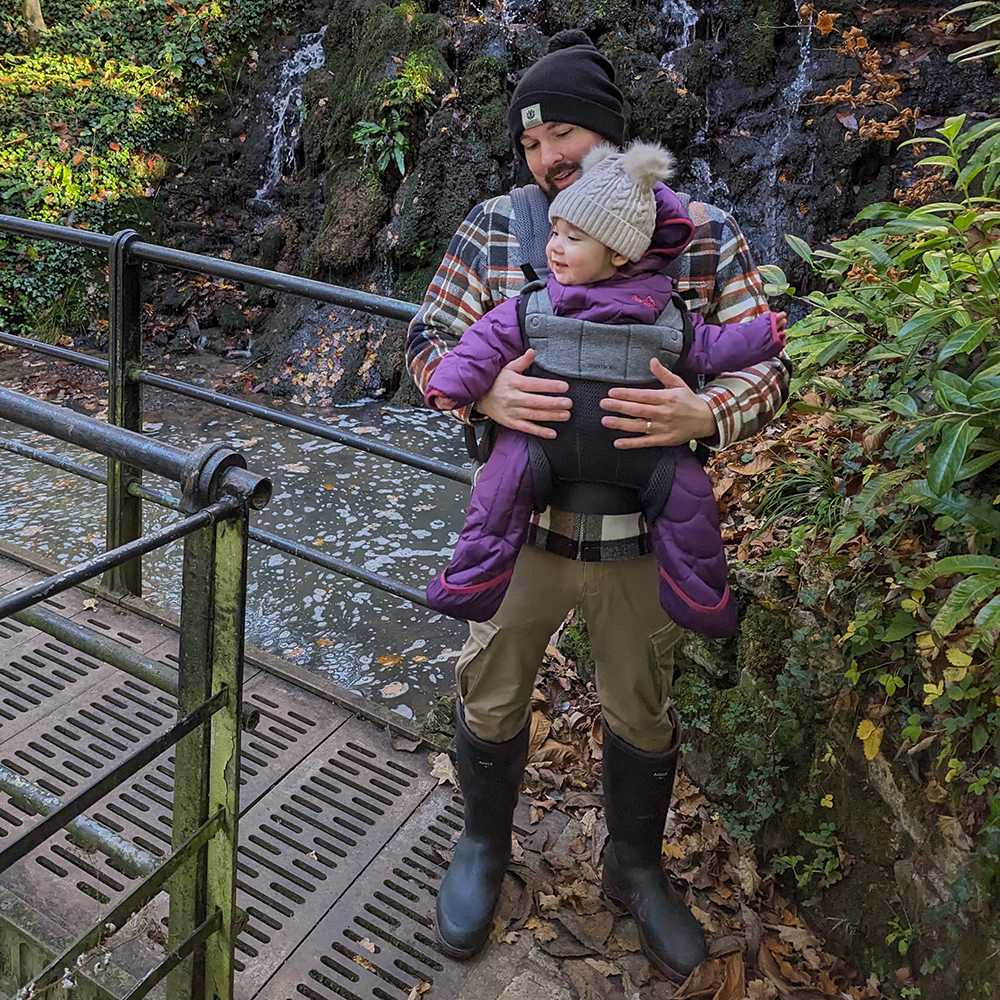 Man wearing Aigle wellies on walk with waterfall in background 