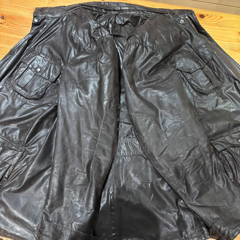 Brown Barbour wax jacket laid flat following rewaxing, showing the restored wax finish across the front.
