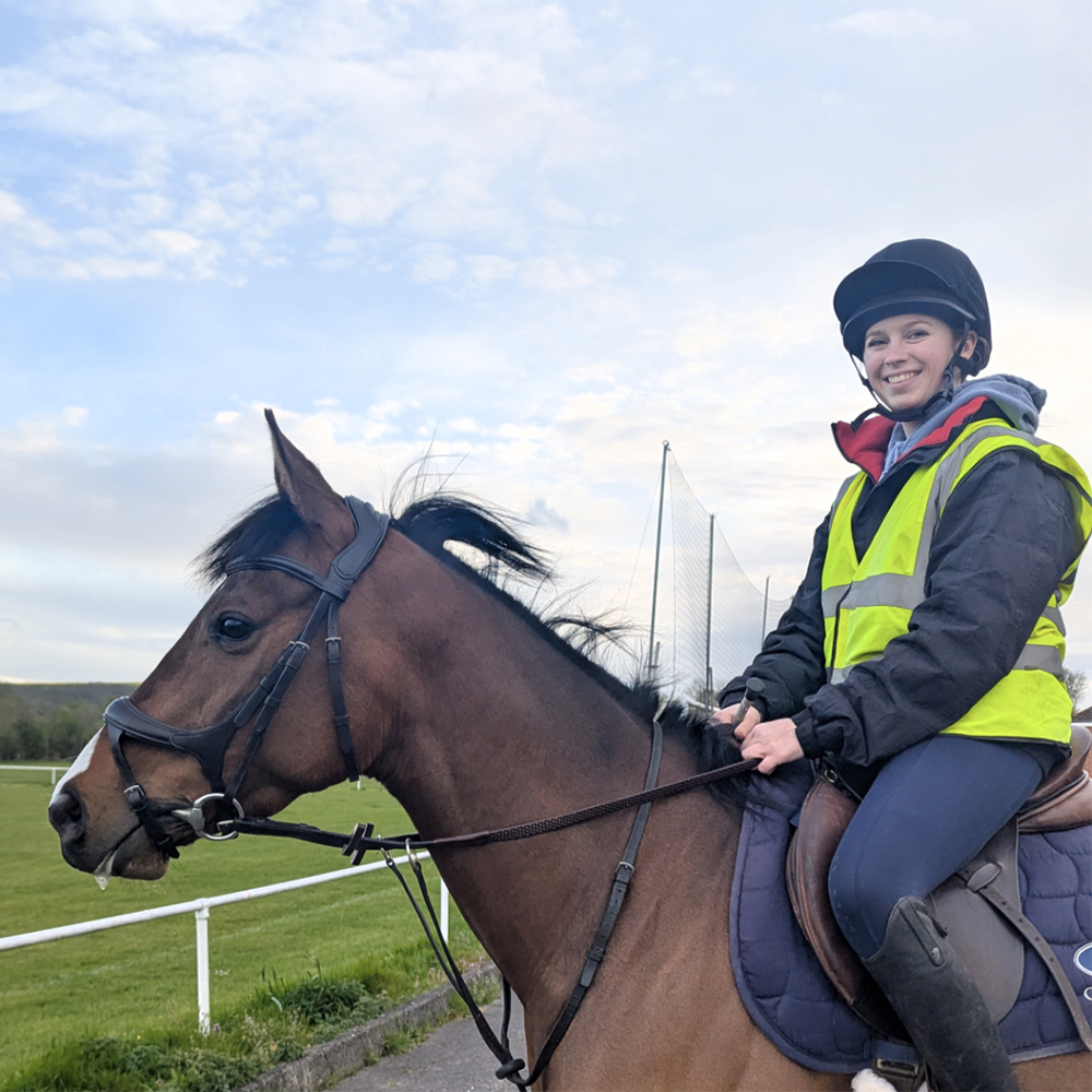 Rider using the Collegiate ComfiTec Vogue Anatomical Bridle on a young OTT Thoroughbred during flatwork.
