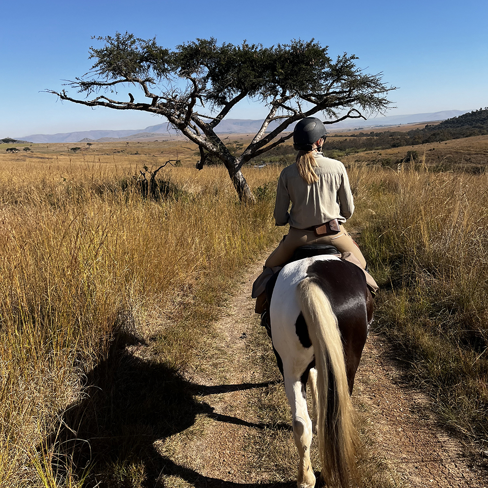 Woman wearing comfortable horse riding clothing on a horseback safari adventure